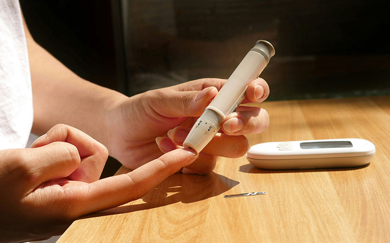 Person using an EpiPen on index finger
