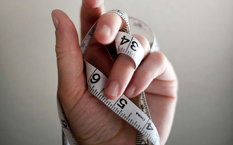 Hand clasping measuring tape